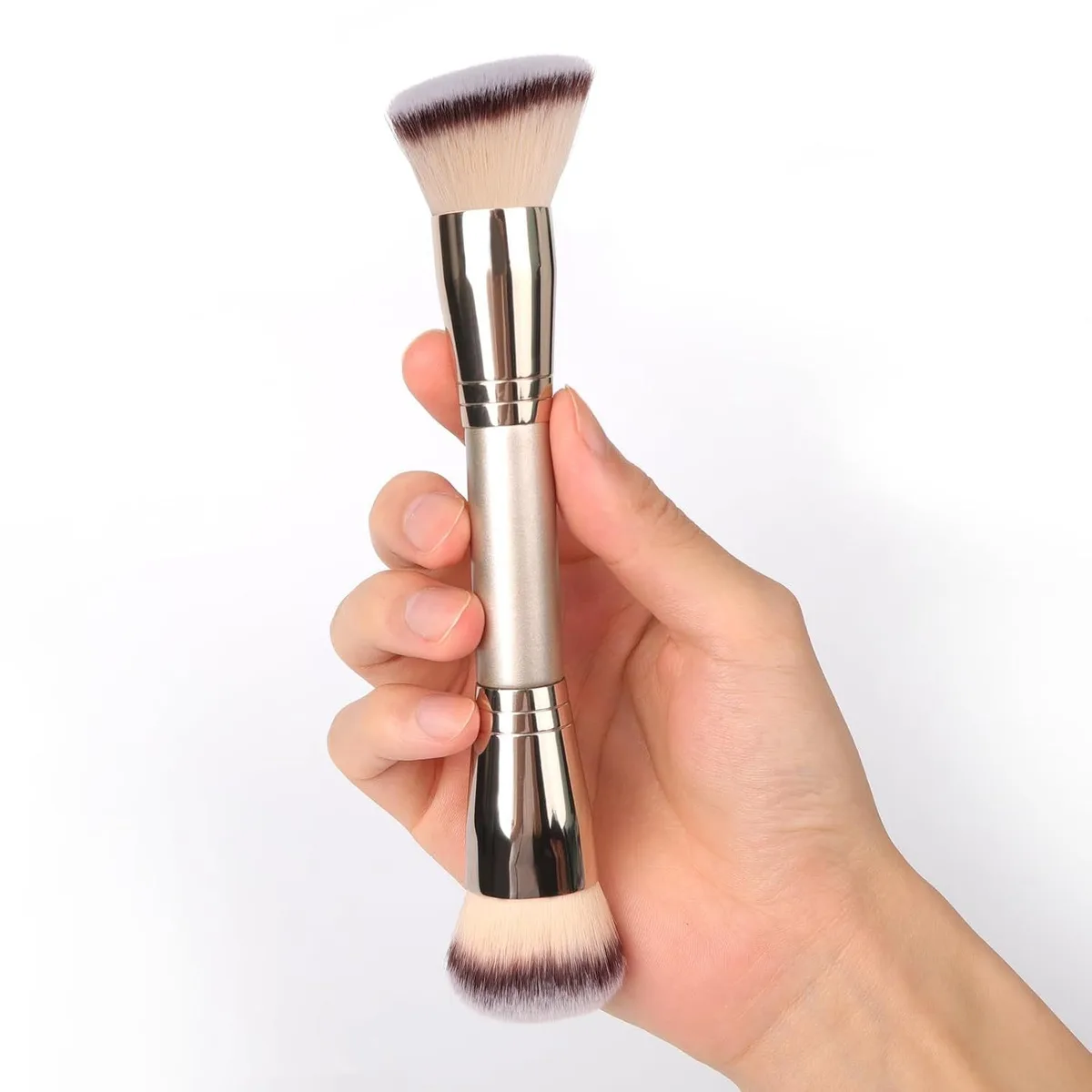dual-ended foundation and powder brush held in hand